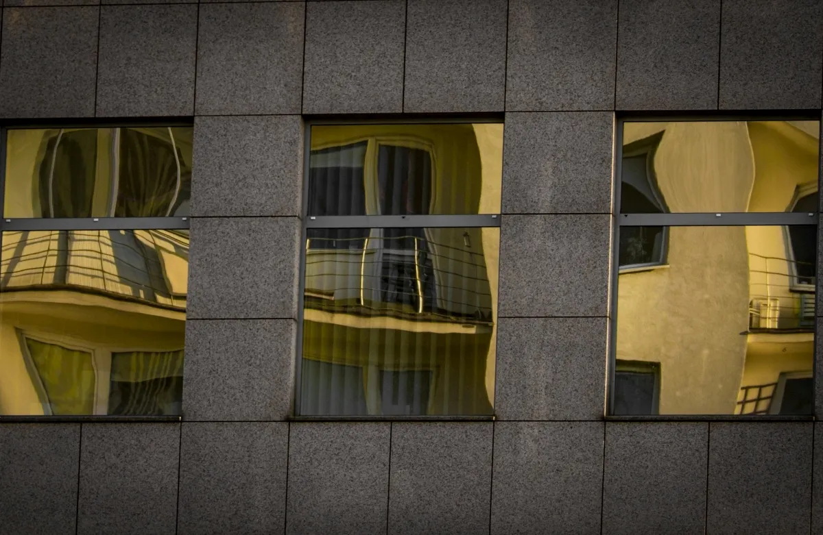 Yellow-lit windows reflected across dark glass panels